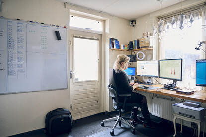 Marjolein aan het werk achter de computer in haar thuiskantoor